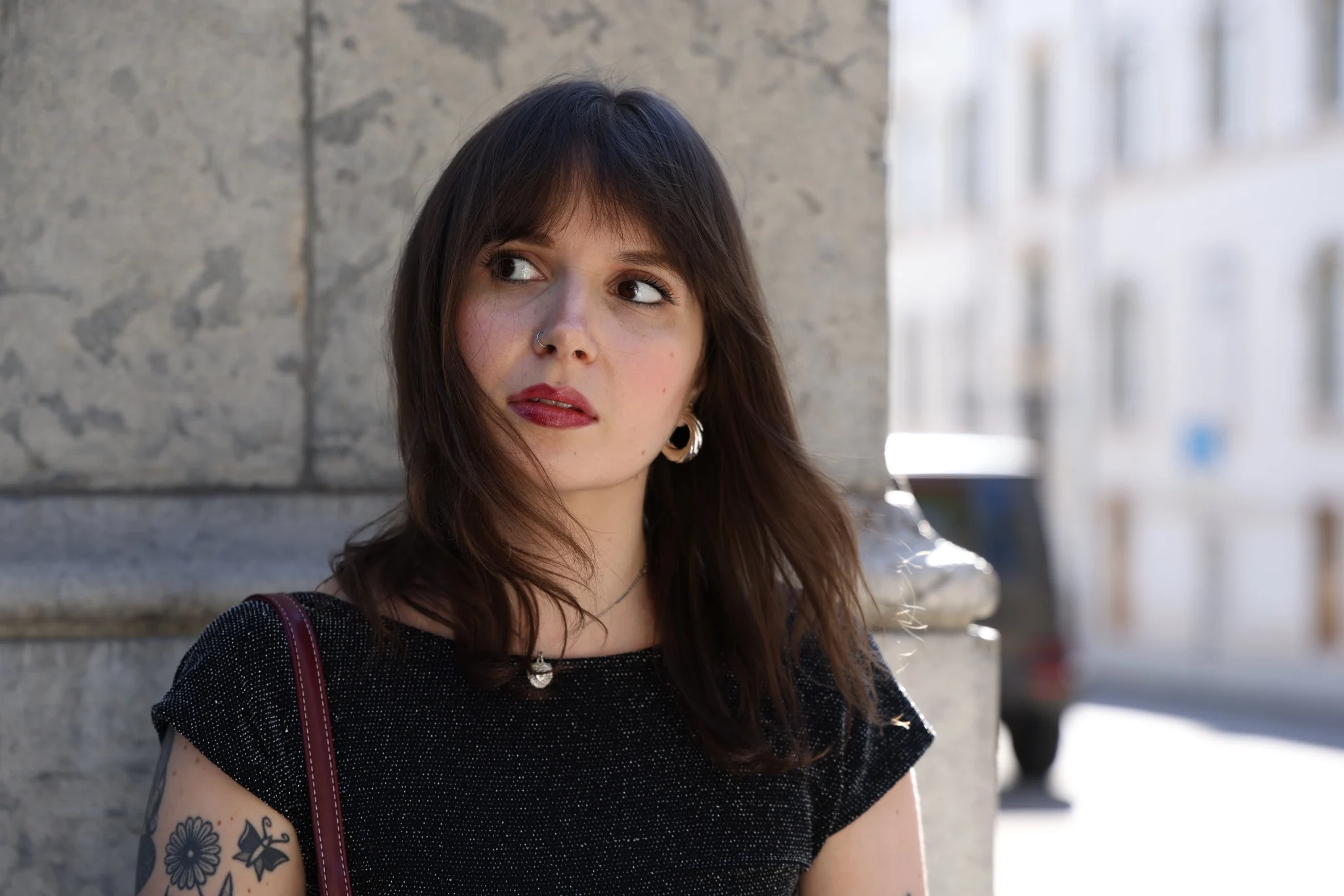 Portrait féminin en lumière naturelle devant un mur en pierre