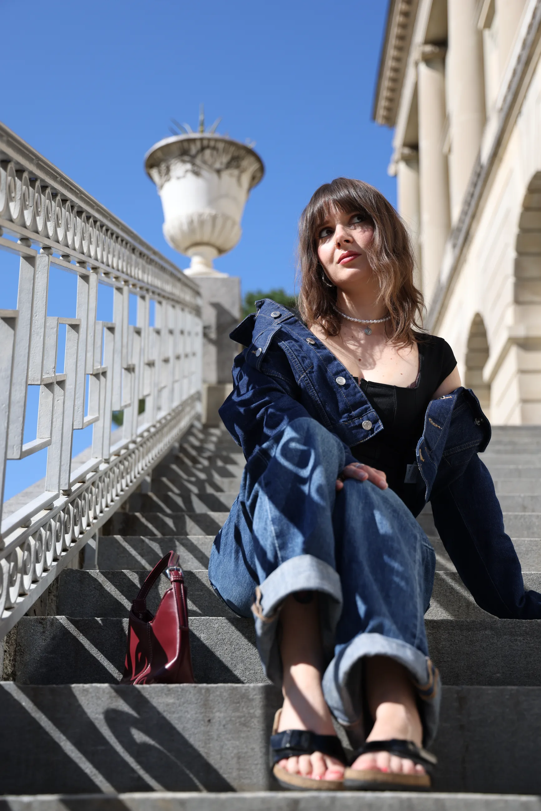 Portrait féminin assis sur des marches en extérieur